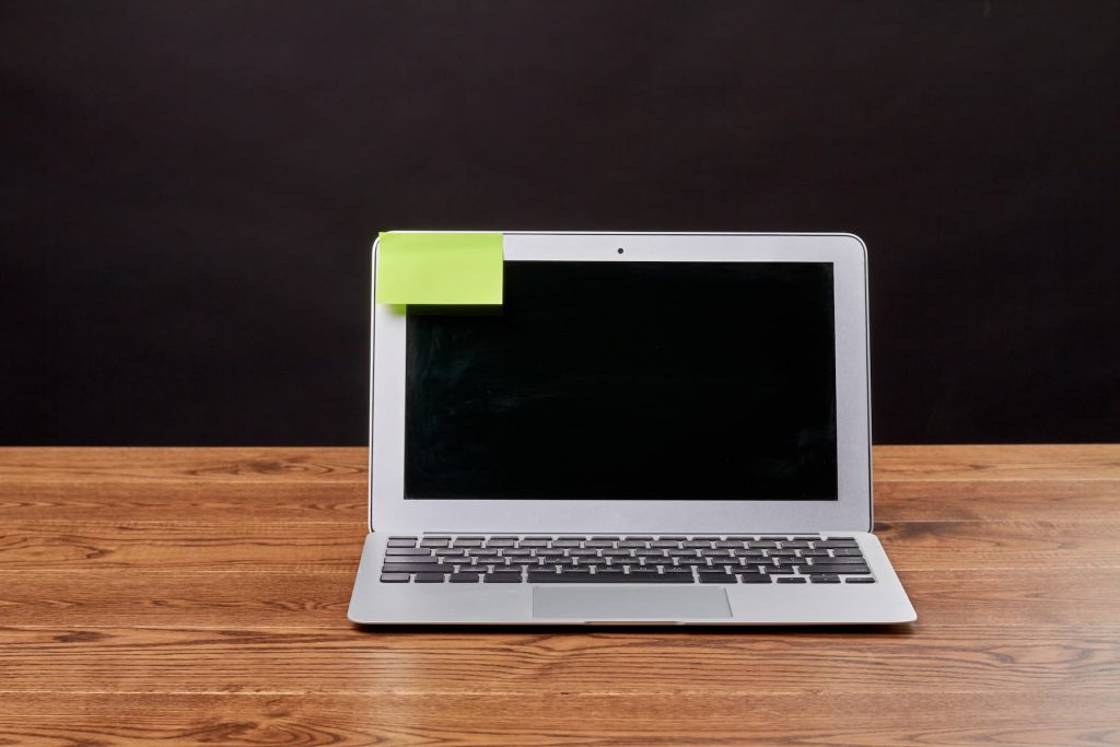 Laptop Macbook air cu note lipicioasă atașată.